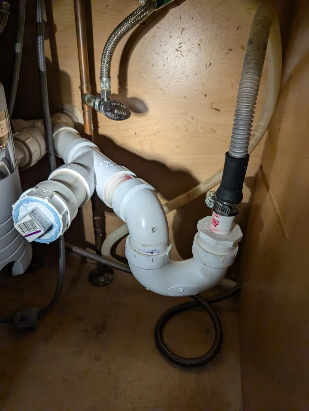 PVC drain trap and fitting installed under a bathroom sink