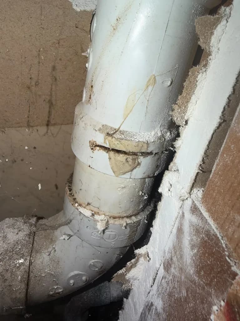 Close-up of a gray PVC pipe coupling and elbow fitting